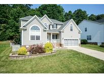 Charming two-story home with a well-manicured lawn, garden, and an attached two-car garage at 212 Mickleson Ridge Dr, Raleigh, NC 27603