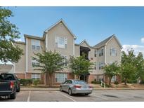 Multi-story home showcasing tan siding, brick accents, well-maintained landscaping, and convenient parking at 2521 Friedland Pl # 303, Raleigh, NC 27617