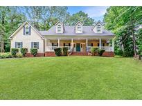 Charming home featuring a welcoming front porch, well-manicured lawn, and classic architectural details at 26 Shadymont Dr, Pittsboro, NC 27312