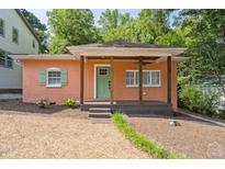Charming home featuring a cozy front porch, accented by a colorful facade, window shutters, and a well-manicured gravel yard at 309 E End Ave, Durham, NC 27703
