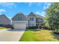 Charming two-story home with a two-car garage, manicured lawn and beautiful curb appeal under a blue sky at 315 Sugarpine Trl, Clayton, NC 27520