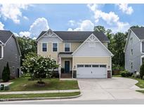 Charming two-story home featuring a well-manicured lawn, flowering tree, and a classic facade at 3441 Jordan Shires Dr, New Hill, NC 27562