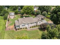 Charming single-story home with well-manicured lawn, carport, fenced yard and separate storage building at 409 Trail Two, Burlington, NC 27215