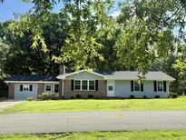 Charming single story home featuring a manicured lawn, brick accents, and black shutters at 41 Lakewood Dr, Roxboro, NC 27573