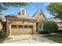 Stunning stone home featuring an attached garage and meticulously maintained landscaping at 4137 Gardenlake Dr, Raleigh, NC 27612