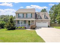 Charming two-story home featuring a cozy front porch and attached two-car garage at 44 Clarke Ct, Angier, NC 27592