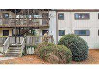 Multi-level condo building featuring wood balconies, neutral siding, and well-maintained landscaping with pine straw at 550 Pine Ridge Pl, Raleigh, NC 27609