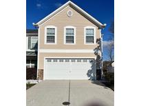 Exterior shot of a two-car garage with white door, beige siding, and white trim around windows at 8836 Thornton Garden Ln, Raleigh, NC 27616