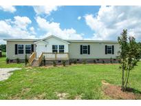 Charming manufactured home with a well-maintained lawn and inviting front porch at 100 Cottonwood Ct, Kenly, NC 27542