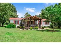 Charming single-story home featuring a covered front porch and well-manicured lawn with tasteful landscaping at 1007 Windward Hill Ct, Middlesex, NC 27557