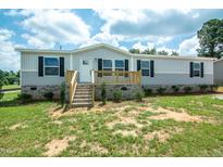 Charming single-story home featuring a light gray exterior, black shutters, and a welcoming front porch at 101 Cottonwood Ct, Kenly, NC 27542