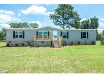 Charming one-story home featuring a freshly cut lawn, and a light gray exterior at 103 Cottonwood Ct, Kenly, NC 27542
