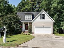 Charming two-story home with a manicured lawn and attached two-car garage and mature trees at 106 Dodge Ln, Smithfield, NC 27577