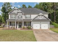 Charming two-story home with a welcoming front porch and a two-car garage at 115 Baystone Dr, Sanford, NC 27332