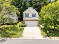 Charming two-story home featuring a two-car garage and beautiful landscaping on a sunny day at 124 River Pearl St, Raleigh, NC 27603