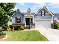 Charming two-story home with blue siding, brick accents, landscaped yard, and inviting front entrance at 210 Olde Liberty Dr, Youngsville, NC 27596