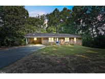 Charming brick home featuring a blue front door, covered carport, and expansive front yard at 3863 Avents Ferry Rd, Sanford, NC 27330