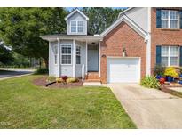 Charming two-story townhome with a brick and siding exterior, a well-manicured lawn, and an attached one-car garage at 428 Grand Pointe Dr, Garner, NC 27529