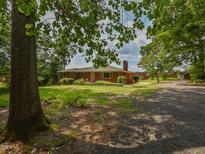 A sprawling single-story red brick home with a chimney and a large yard at 4324 Garland Dr, Raleigh, NC 27606