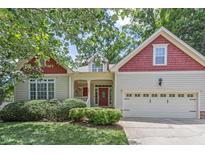Charming home featuring red and beige exterior, manicured lawn, and a two-car garage at 499 Chatham Forest Dr, Pittsboro, NC 27312