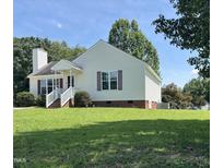 Charming one-story home with manicured lawn, brick foundation, white siding, and inviting front porch at 6 Boxley Dr, Wendell, NC 27591