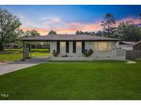Charming one-story home featuring a well-manicured lawn and a covered carport at 1020 Benning St, Durham, NC 27703