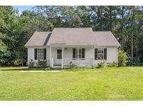 Charming home featuring a front porch, complemented by a well-maintained lawn and mature trees at 158 Red Oak Dr, Smithfield, NC 27577