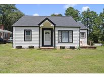 Charming one-story home featuring black and white accents and a well-manicured lawn at 202 W Ransom St, Fuquay Varina, NC 27526
