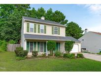 Charming two-story home with green shutters and a well-manicured lawn and mature trees at 207 Stonecreek Dr, Apex, NC 27539