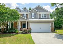 Charming two-story home featuring a stone and siding exterior, manicured lawn, and an attached two-car garage at 237 Northlands Dr, Cary, NC 27519