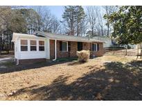 Brick ranch-style home with black shutters and a small front yard in a quiet, wooded neighborhood at 2801 Quince Dr, Raleigh, NC 27610