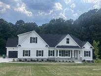 Beautiful new home with white siding, dark shutters, and a well-manicured lawn at 291 Busterfield Ct, Benson, NC 27504