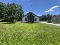 Charming single-story home featuring a well-maintained lawn and welcoming front porch at 3241 Rowena, Durham, NC 27703