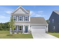 Charming two-story home with gray siding, blue shutters, a landscaped yard, and a welcoming front porch at 34 Mable Court # 22, Lillington, NC 27546
