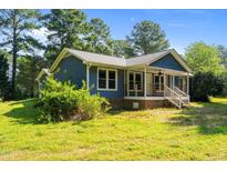 Charming blue home featuring a cozy front porch and well-maintained lawn at 545 Barnette Rd, Louisburg, NC 27549