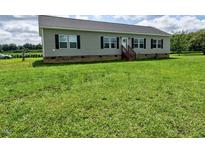 Charming one-story home featuring black shutters, a large front yard, and gray siding at 555 Hinnant Rd, Selma, NC 27576