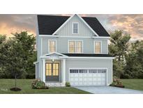 Charming two-story home with gray siding, black roof, attached garage, and manicured landscaping at 1217 Barreto Dr, Wendell, NC 27591