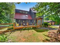 Charming two-story home featuring a metal roof, inviting front porch, and a beautifully landscaped yard at 133 Acorn Ln, Pittsboro, NC 27312