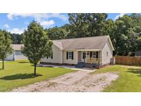 Charming one-story home featuring a well-maintained lawn and a gravel driveway leading to the residence at 32 N Dandelion Green Ct, Selma, NC 27576