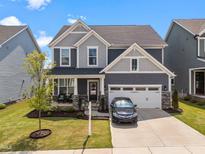 Charming two-story home with a two-car garage, welcoming front porch, manicured lawn, and beautiful curb appeal at 36 Contentment Ln, Fuquay Varina, NC 27526