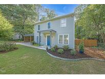 Charming two-story home with light gray siding, blue front door, and an inviting landscaped front yard at 4 Galaxy Ct, Durham, NC 27705