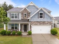 Beautiful two-story home featuring stone accents, a two-car garage, and a well-manicured lawn at 4014 White Kestrel Dr, Raleigh, NC 27616