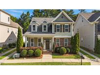 Charming two-story home featuring a welcoming front porch and beautifully landscaped front yard at 511 Mill Hopper Ln, Apex, NC 27502