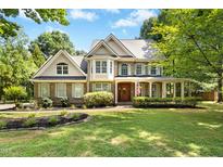 Beautiful two-story brick home with a covered porch and manicured lawn under a blue sky at 55 Kensington Dr, Youngsville, NC 27596