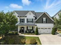 Charming two-story home with a welcoming front porch, manicured lawn and a two car garage at 5716 Sarcelle St, Holly Springs, NC 27540