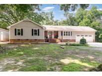 Charming one-story home with a brick accent, a manicured lawn, and mature trees at 5840 Fayetteville Rd, Raleigh, NC 27603