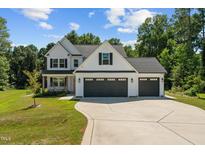 Stunning two-story home with a three-car garage, well-manicured lawn, and hanging porch swings at 72 Copperhead Ln, Benson, NC 27504