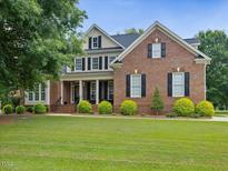 Beautiful brick two-story home with a covered front porch and well-manicured lawn at 9045 Chelsea Dr, Raleigh, NC 27603