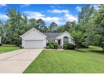 Charming home featuring a manicured lawn, attached garage, and well-maintained landscaping at 2003 Zbonack Ct, Creedmoor, NC 27522