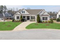 Charming single-Gathering home featuring lush green lawn, concrete drive and traditional architectural details at 301 Rocking Ranch Ct, Cary, NC 27519